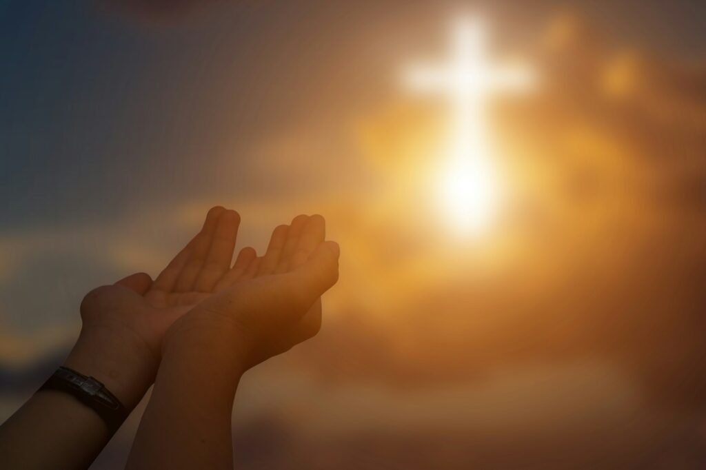 Silhouette of christian open hands to praying for blessing from god at sunset background.